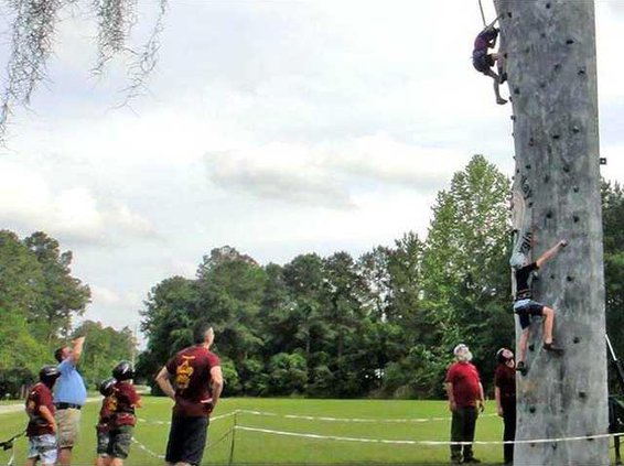 2 Boy Scouts scaling rock wall