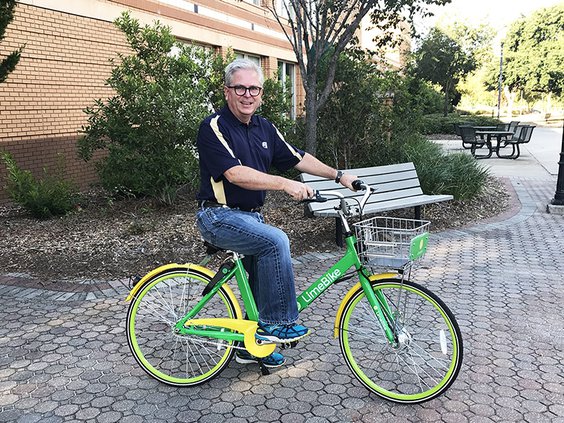 DeWayne Grice shows off a LimeBike on the Georgia Southern campus.