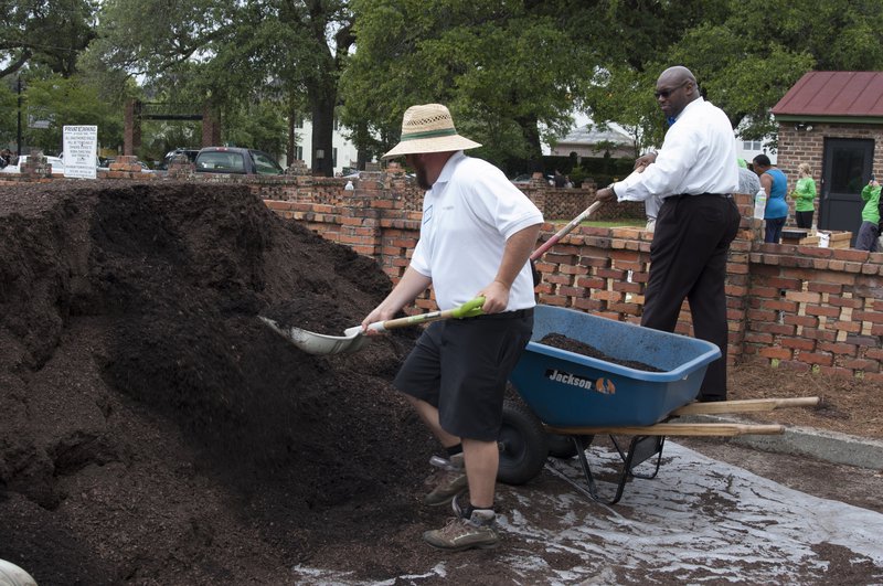 Victory Gardens' David Hislop moves soil to the raised garden beds with the help of C. MeGill Brown, pastor of Second African Baptist Church, Savannah Police Department Chaplain, and president of Curtis V. Cooper Primary Health Care's Board of Directors.