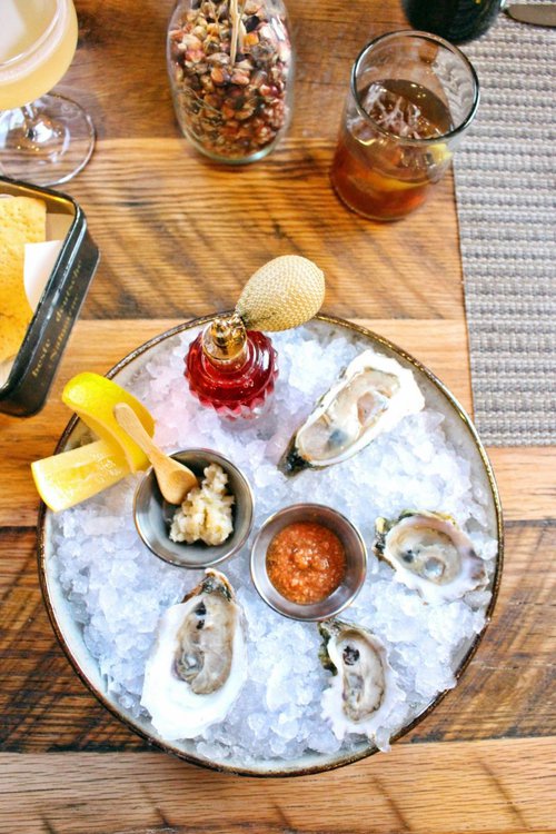 Fresh shucked oysters with an antique perfume bottle filled with house made mignonette, peanut horseradish and cocktail sauce.