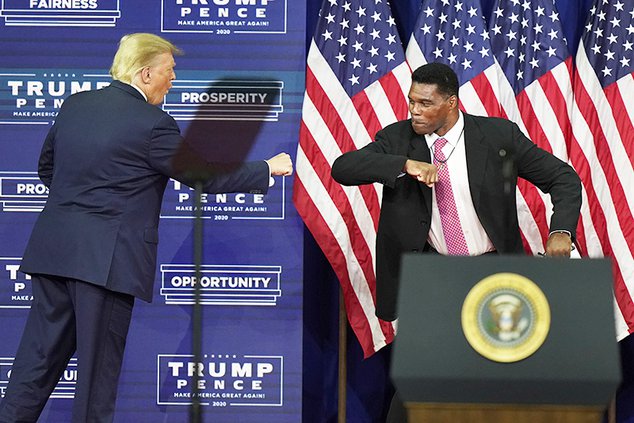 In this Sept. 25, 2020, file photo, President Donald Trump elbow bumps with Herschel Walker during a campaign rally in Atlanta. Walker appears to have a coveted political profile for a potential Senate candidate in Georgia.