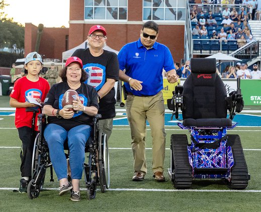 Photo Courtesy A.J. Henderson/Georgia Southern Athletics Army veteran Karen Dery, holding football, received a specialty "Trackchair" during a ceremony Saturday at Paulson Stadium. Pictured with Dery are, left to right, her grandson Justin, husband John D