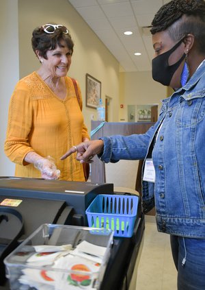 Poll worker Rhenetri Washington, right, helps Chris Van Tassell finish casting her ballot during early voting at the Bulloch County Annex on Friday, Oct. 15.