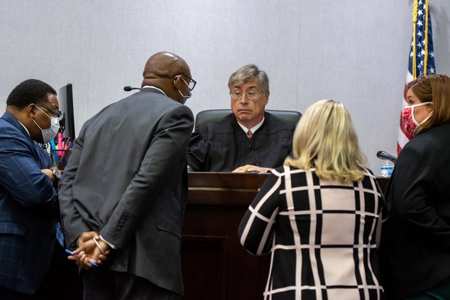 In this file photo, Superior Court Judge Michael T. Muldrew, center, listens to defense attorneys for Marc Wilson, on the left, including Francys Johnson, on the far left, and the prosecution team from the district attorney's office during a hearing in Au