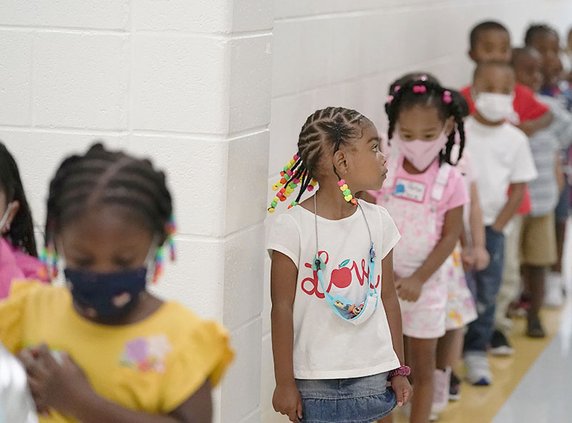 Students walk down the hallway at Tussahaw Elementary school in August 2021, in McDonough, Ga., with some in masks and some unmasked. Gov. Brian Kemp has said he would propose a law that would let parents opt their students out of masks in Georgia school