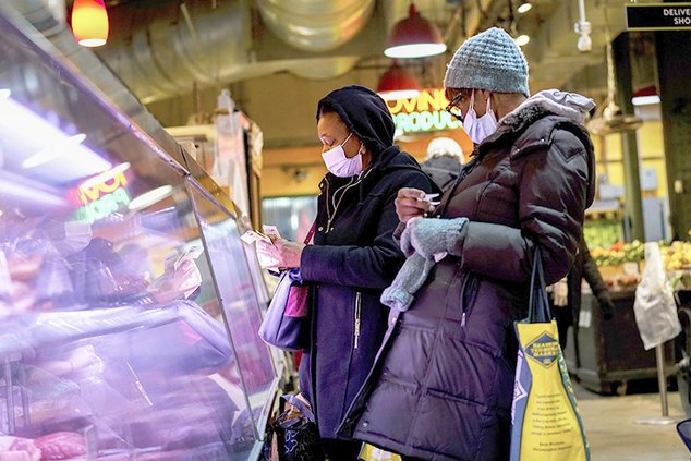 Customers wearing face masks to protect against the spread of the coronavirus shop at the Reading Terminal Market in Philadelphia, Wednesday, Feb. 16, 2022. Philadelphia city officials lifted the city's vaccine mandate for indoor dining and other establi