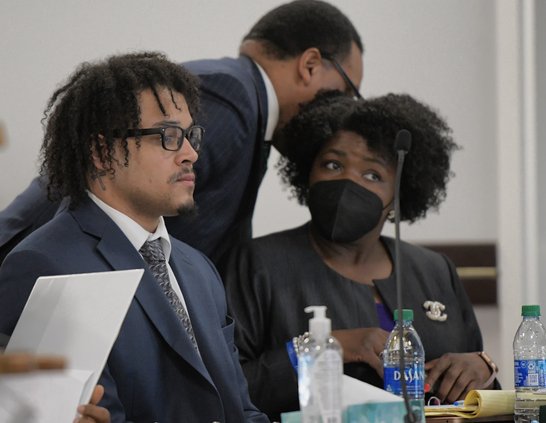 William Marcus "Marc" Wilson, left, takes his place as his defense team confers with one another during his immunity hearing on Wednesday, March 2. Wilson, who faces one charge of felony murder and five charges of aggravated assault and a charge of posses