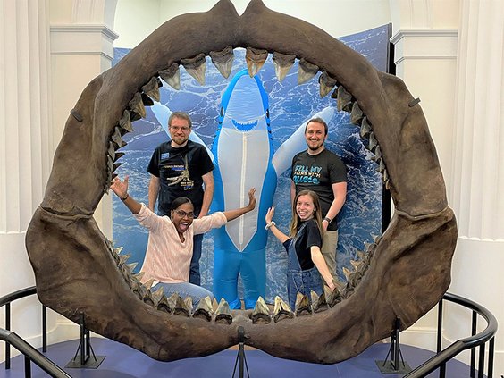 SPECIAL PHOTO/Georgia Southern Museum Framed by megalodon jaws, Georgia Southern Museum staff members – left to right, front row, Assistant Director Lashanda Hicks-Griffin and student assistant Sydney Kelly; back row, graduate assistant Stephen Cravey, st