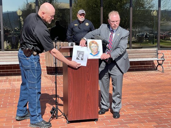 In this photo provided by The Georgia Bureau of Investigation investigators hold a photo of Stacey Lyn Chahorski, left, of Norton Shores, Mich., and a composite sketch of her in Trenton, Ga., March 24, 2022. Georgia and federal officials said on Tuesday,