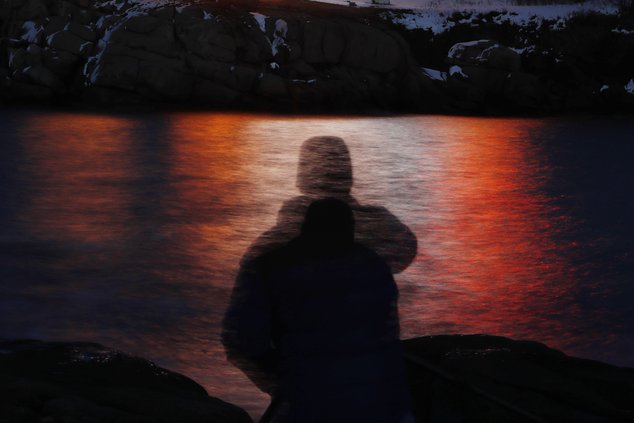 In this photo made with a long exposure, a man is silhouetted against lights reflected in the waters off Cape Neddick in Maine on Dec. 11, 2017. U.S. doctors should regularly screen all adults under 65 for anxiety, an influential health guidelines group p