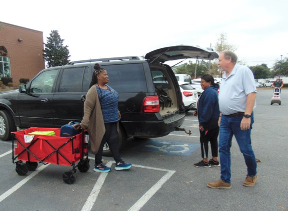Bulloch County Election Supervisor Shontay Jones, left, brings a wagon of election materials out for Portal precinct Assistant Poll Manager Linda Williams, middle, to drive to Portal in preparation for the Tuesday, Dec. 6, 2022, runoff election while Ronn