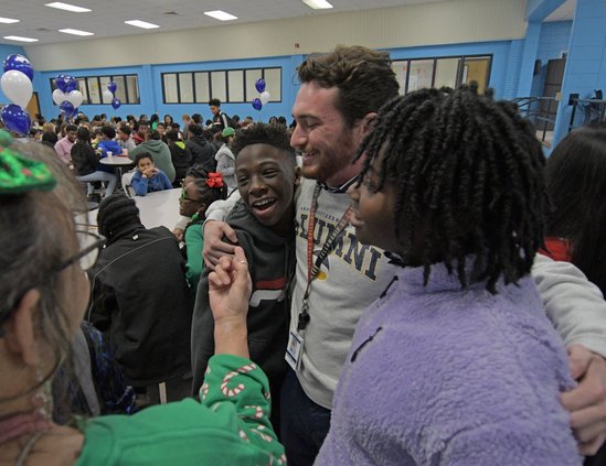 After deciding to skip his college graduation, Williams James Middle School teacher Zachary Barrow is mobbed by sixth grade students following Barrow's surprise private graduation ceremony at the school on Tuesday, Dec. 13.