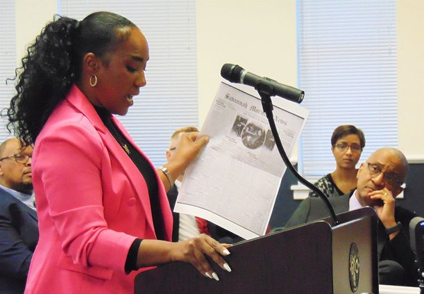 Adrianne McCollar, one of the two Statesboro-Bulloch Remembrance Coalition co-chairs, holds a copy of the front page of the Aug. 30, 1904, Savannah Morning News as she speaks to Statesboro City Council on Feb. 21, 2023. Page 1 of the Savannah paper 118 ye