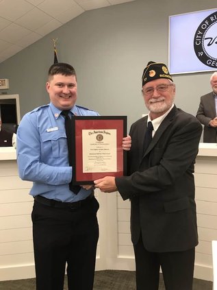 Fire Fighter Johnson receives his award from CDR Awtrey.