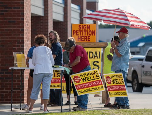 The Bulloch Action Coalition set up tables for community members to sign their petitions opposing approval of the Hyundai wells in Bulloch County outside a Georgia EPD meeting and hearing at Southeast Bulloch High School on Tuesday, August 13.