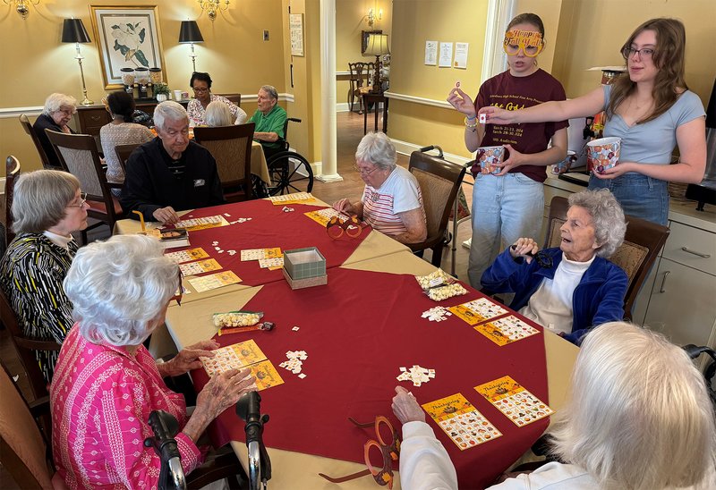 fellow Statesboro High students Lucy Keeley, standing on left, and Carley Peden, standing on right, helped Caroline Bland with the Fall Festival at Willow Pond. They are shown below calling out numbers for Bingo.