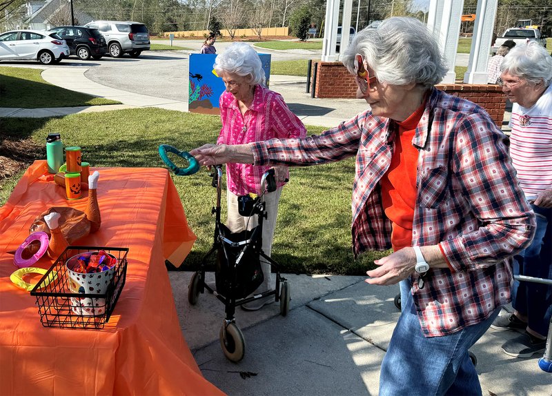 Sally Deal, who has been a Willow Pond resident for three years, plays a Thanksgiving ring toss game. Chick-fil-A and Cork's Kettle Corn donated food for the event.