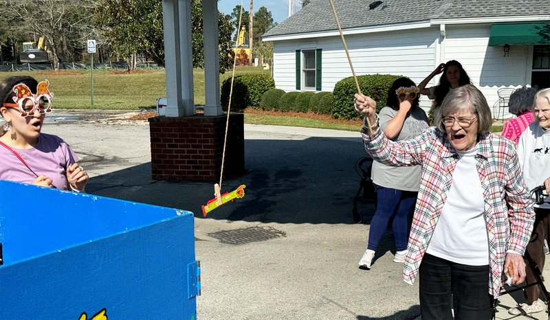 Willow Pond Assisted Living resident Carolyn Mandes catches some candy while playing a fishing game at the festival.