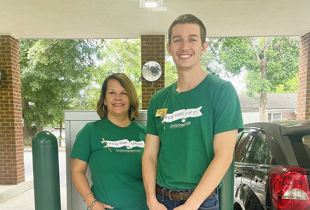 Queensborough Branch Manager Erin Burnsed, left, and Ayden Stewart stand in front of the newly installed interactive teller machine at its branch on South Main St.