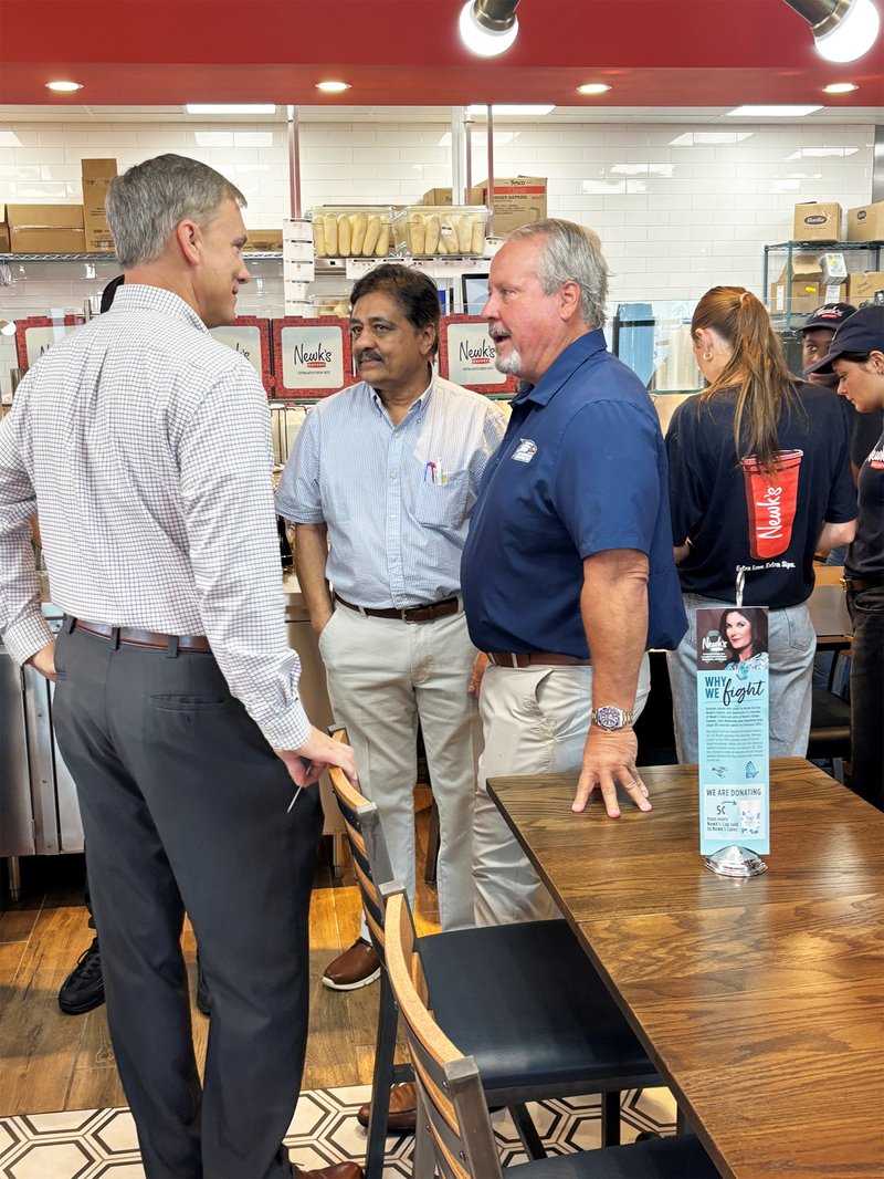 Joel Hanner, left, area manager for Georgia Power, and Newk's Eatery partners Tiku Shroff, center, and Rick Howard talk prior to the restaurant's official grand opening.