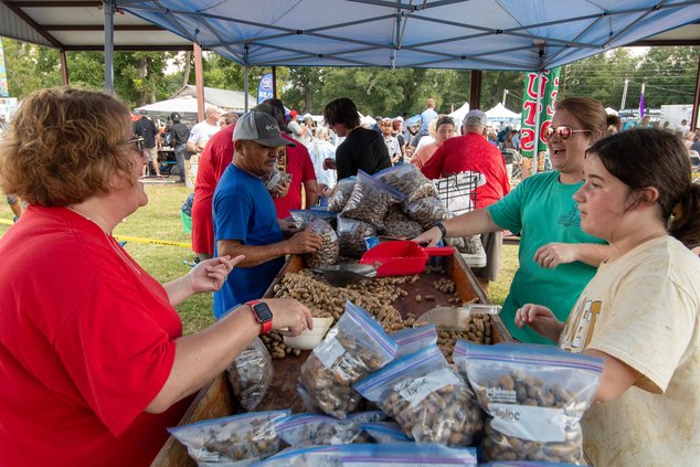 SCOTT BRYANT/Herald file Kelly Murray, left, and Ursula Lightsey, middle right, share a laugh as they, Blakelee Lightsey, right, and Martinez Esau  bag up freshly boiled peanuts for The Cook Shack during the 2024 Brooklet Peanut Festival.The 2025 festival
