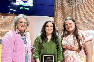 Tiffany Burgess, center, holds the Connie Kight Award for her dedication and service to the Adults 50+ program. Below, a plaque recognizing Kimberly Sharpe's 25 years of service is shown.