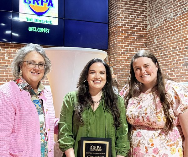 Tiffany Burgess, center, holds the Connie Kight Award for her dedication and service to the Adults 50+ program. Below, a plaque recognizing Kimberly Sharpe's 25 years of service is shown.