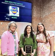 Tiffany Burgess, center, holds the Connie Kight Award for her dedication and service to the Adults 50+ program. Below, a plaque recognizing Kimberly Sharpe's 25 years of service is shown.