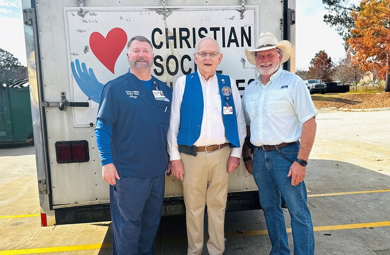 East Georgia Regional CEO Stephen Pennington, David Keene, the Hospital Auxiliary's longtime president, and Christian Social Ministries’ John Long stand outside the packed food trailer. Long and Christian Social Ministries began distributing the food on M