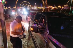 Chief Ben Tapley and other members of the Bulloch County Fire Department collect donations for Christian Social Ministries as TMT Farms Christmas lights visitors drive through the show one last time on Saturday, Dec. 27.