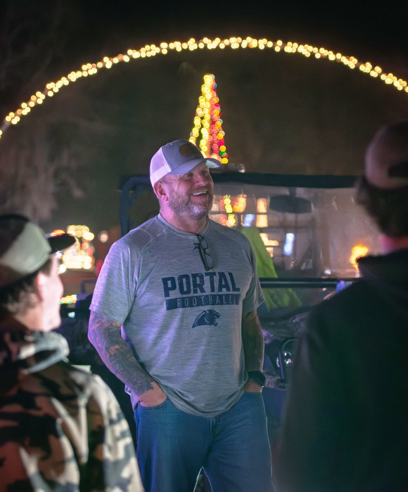 Tyler Thompson, center, son of Roy and the late Deborah Thompson, shares some laughs with people who have helped keep the TMT Farms Christmas lights going in recent years while hosting visitors for the last time Saturday night.