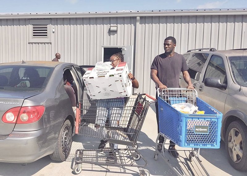 Clients of the Statesboro Food Bank use shopping carts to take supplies to their cars after receiving food for the week from the new Food Bank facility on Miller Street.