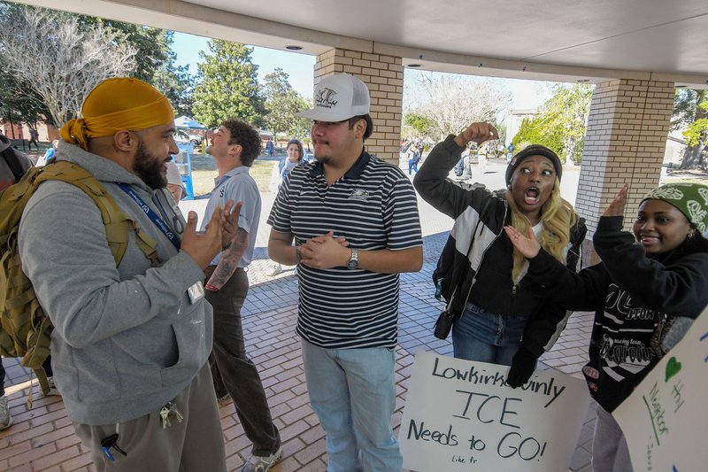 ICE supporter Michael Sanchez, 19, of Griffin, center, wades into the middle of a student-organized protest against ICE and debates fellow student Kyler Gregory of Statesboro, left. Sanchez says his father is a Mexican immigrant who did things the right w
